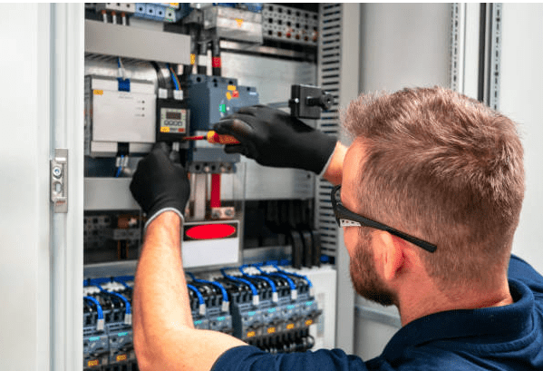 Man fixing circuit breaker while carrying out electrical services in London